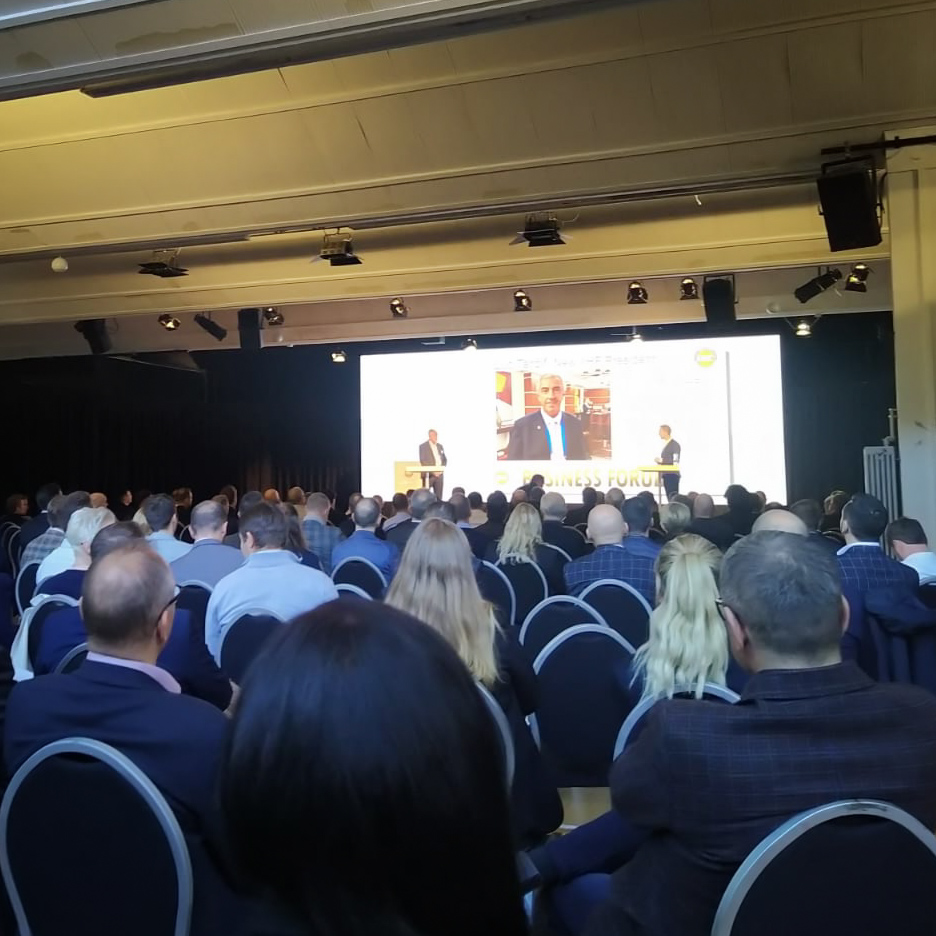 Two people are having a presentation in front of an audience.